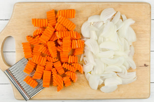 istock Variously sliced for cooking carrots and onions on a cutting board 684848922