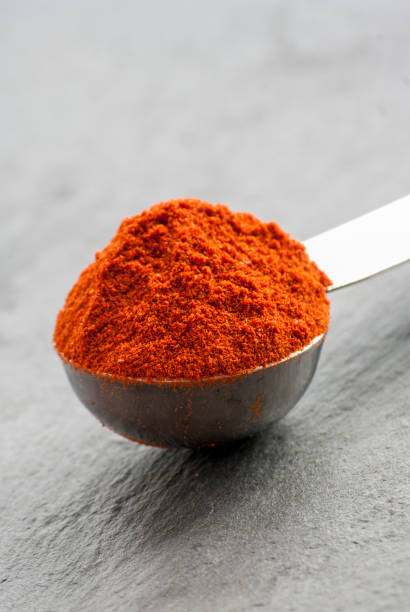 istock Ground chili pepper in a spoon on a dark background, macro shot, selective focus 684849540