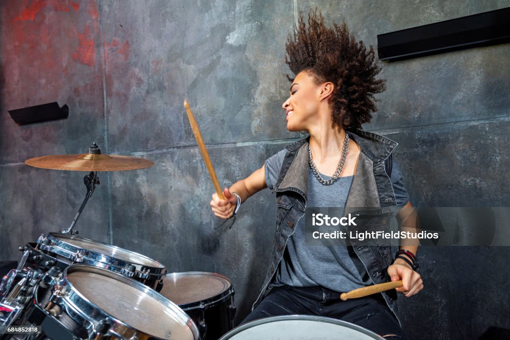 portrait of emotional woman playing drums in studio, drummer rock concept Drummer Stock Photo
