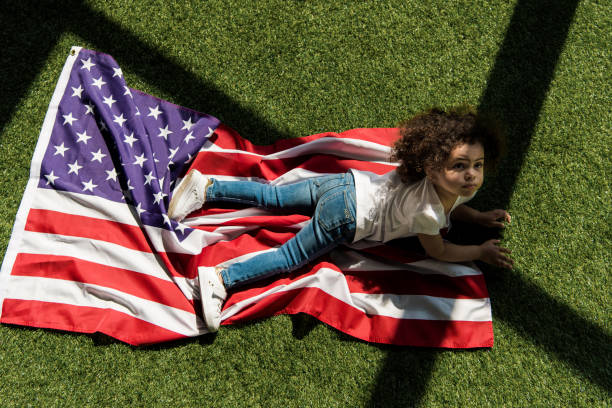 istock girl with american flag on grass 684869892