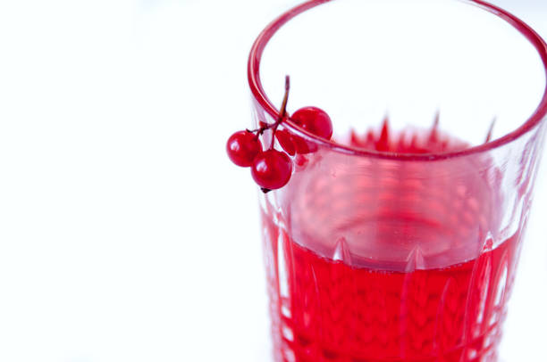 Red refreshing cocktail prepared by the bartender on a black background, party night