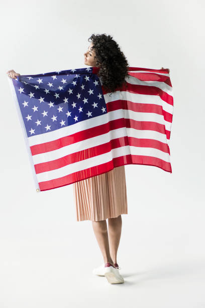 istock woman standing with american flag 684873372