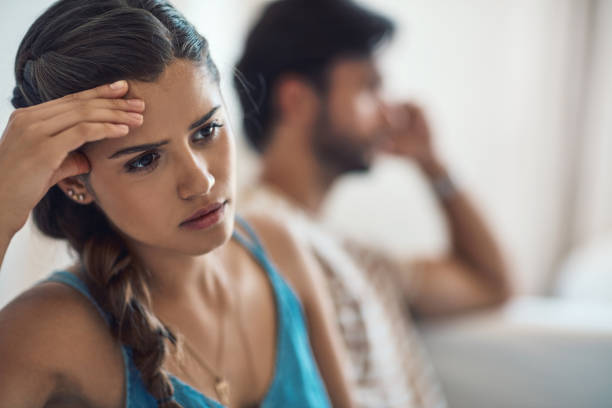 I can't believe he said that Shot of a young couple having an argument while sitting on their couch at home irritation photos stock pictures, royalty-free photos & images