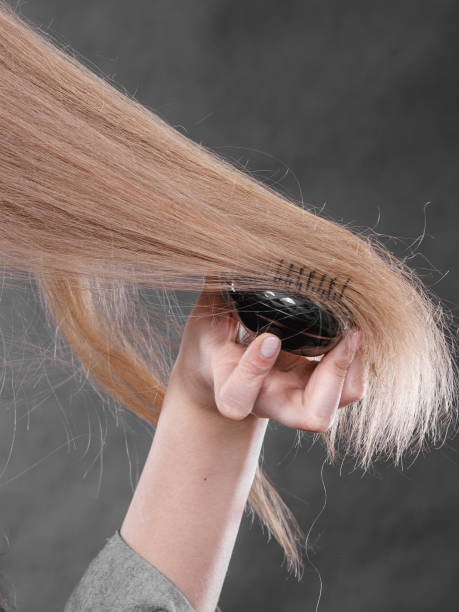 istock Blonde woman combing her hair. 684880068