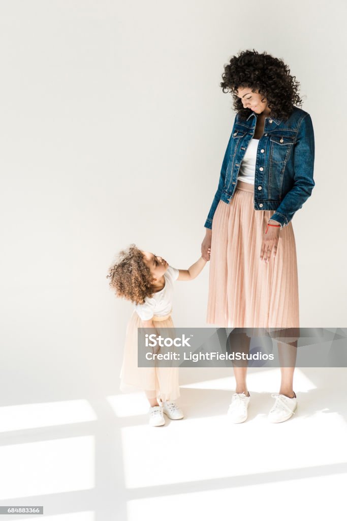 mother and daugter holding hands Happy african american family, mother and daugter holding hands on white Studio - Workplace Stock Photo