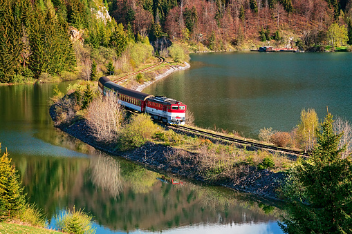 Train passing through lake near Mlynky village in the Slovak Paradise (Slovensky raj) national park, Slovakia.
