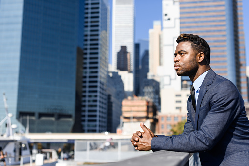 Young businessman in front of the office building, Manhattan, New York