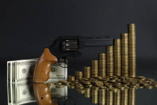 istock arrangement of coins and gun on grey background 684929170