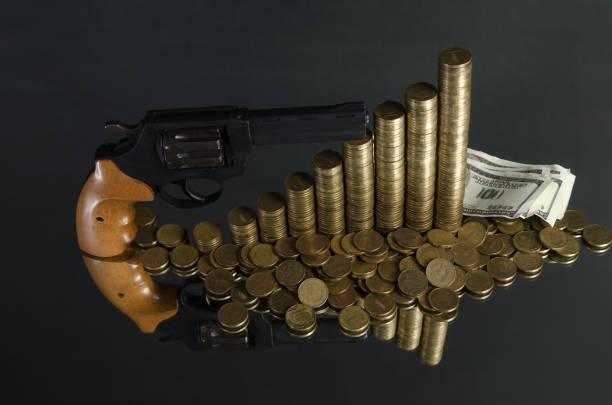 istock arrangement of coins and gun on grey background 684931310