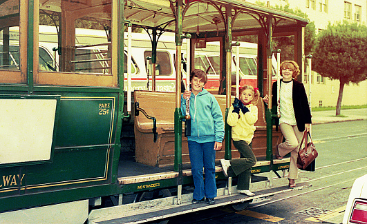 Vintage photo from the eighties featuring a mother and her children on a trolley-car in San Francisco, USA.