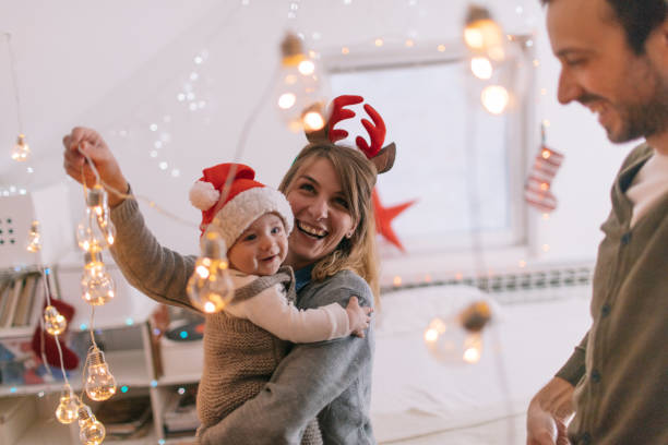 Decorating for Christmas holidays Photo of a cheerful young family with one child, decorating for the first Christmas they are spending together with a baby rudolph the red nosed reindeer photos stock pictures, royalty-free photos & images