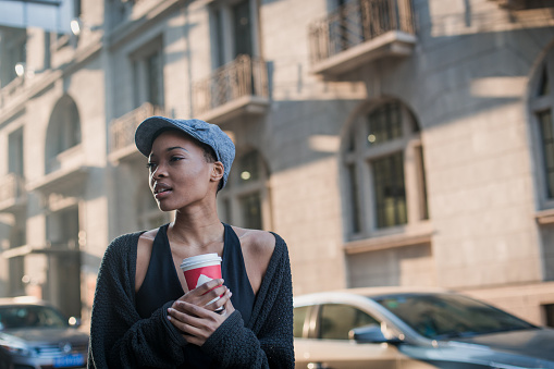Beautiful young black woman enjoying the single life through the city while drinking coffee to go.