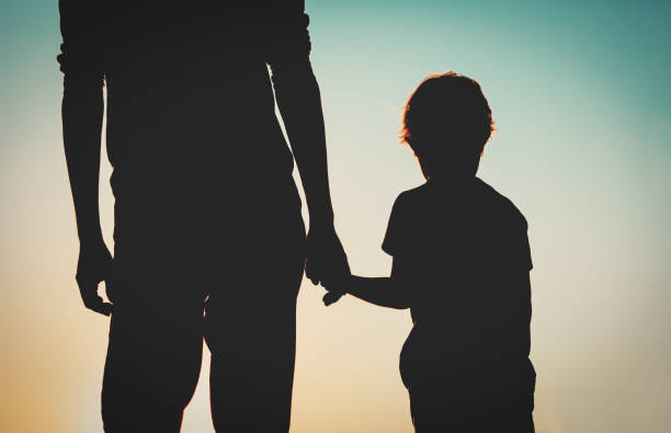 istock silhouette of father and son holding hands at sunset 684947348