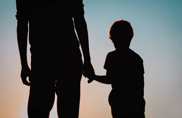 istock silhouette of father and son holding hands at sunset 684947634