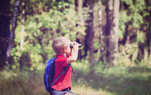 istock little boy travel in nature looking through binoculars 684947732
