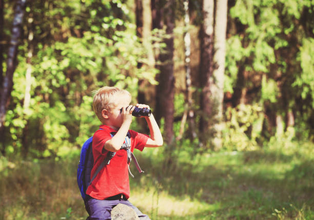istock little boy travel in nature looking through binoculars 684947832