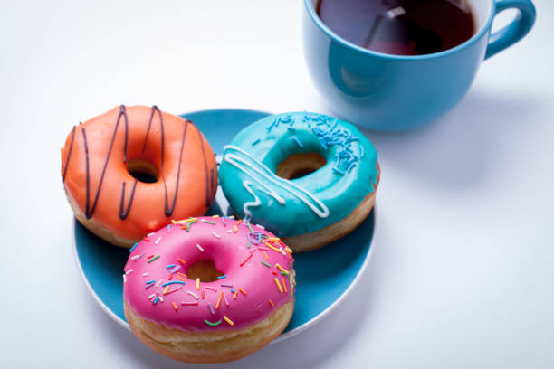 istock A cup of tea and a plate with donuts in a glaze on an white background 684954834