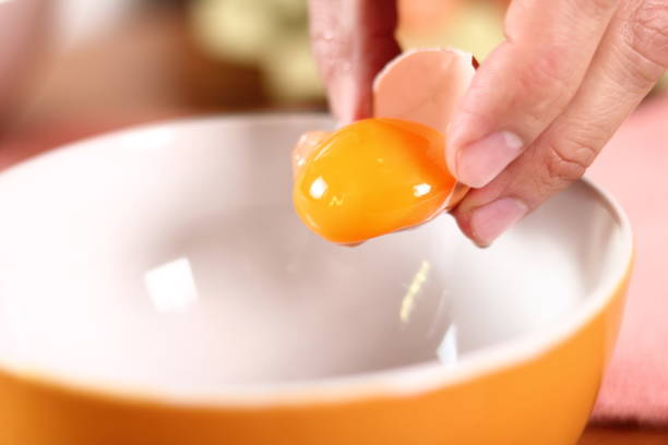 istock Separating egg yolk from white. Making mayonnaise with a wooden spoon. 684959136