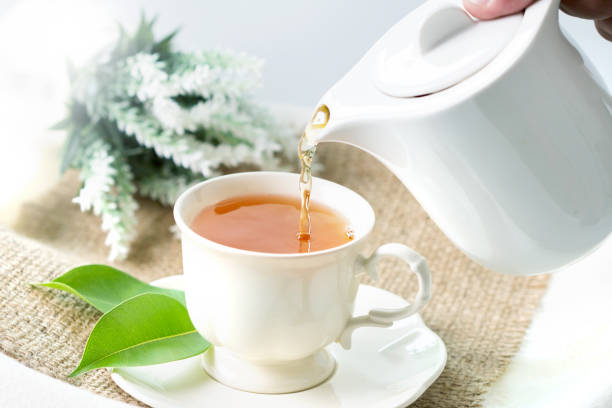 istock Close up pouring hot black tea in a white tea cup ,  Tea ceremony time concept 684961984