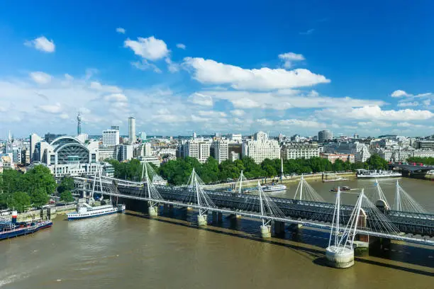 London panorama with Hungerford Bridge over Thames River (Charing Cross Bridge), Victoria Embankment and urban architectures. United Kingdom