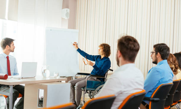 istock Person in wheelchair drawing project draft on flip chart 684974040