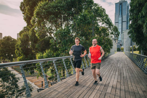 freunde joggen im park - melbourne skyline city australia stock-fotos und bilder