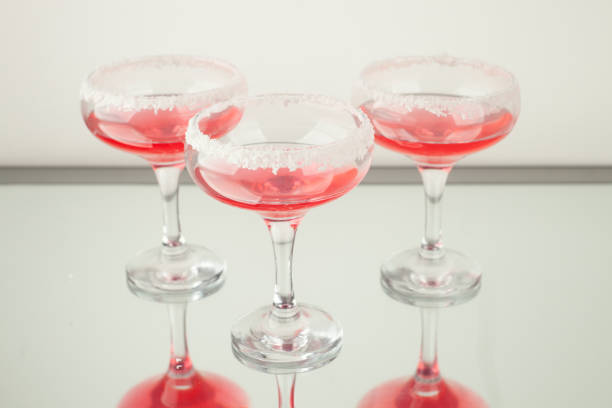 Pink lady cocktails in glasses decorated with coconut for Valentines day, party background