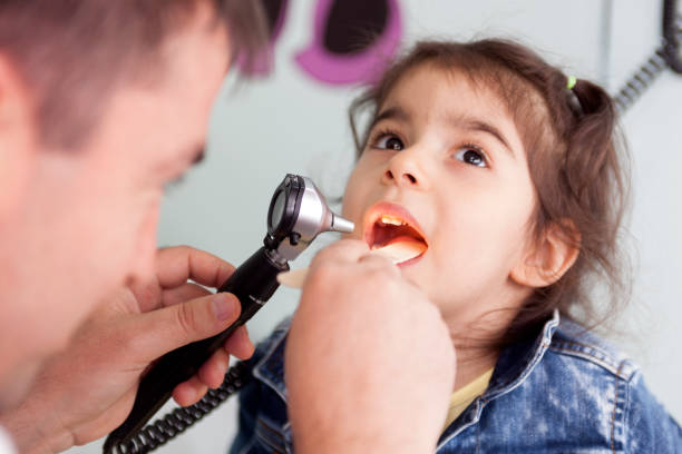 pediatra che esamina la gola di una bambina - dentist family doctor dental hygiene foto e immagini stock