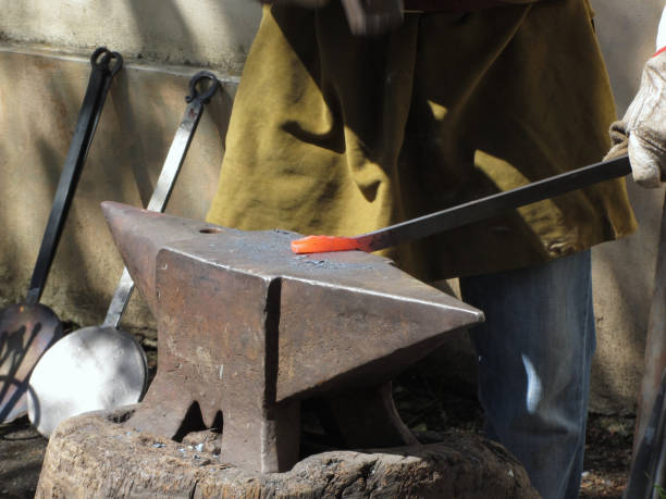 istock Blacksmith manually forging the molten metal with hammer on the anvil 685046498