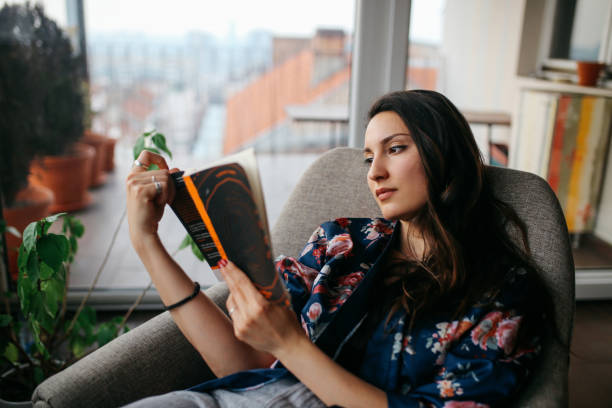 istock Young woman reading at home 685046620