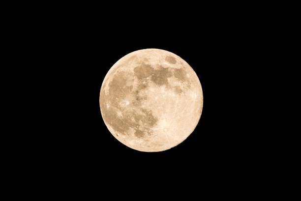 Nice full moon with soft yellow color an visible craters Horizontal photo of full moon. Moon with nice soft yellow color. Visible craters on the edge of space body. The bright and light areas on surface are clearly visible. Space around is black. moonlight photos stock pictures, royalty-free photos & images