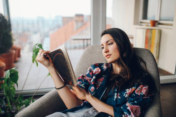 istock Young woman reading at home 685049606