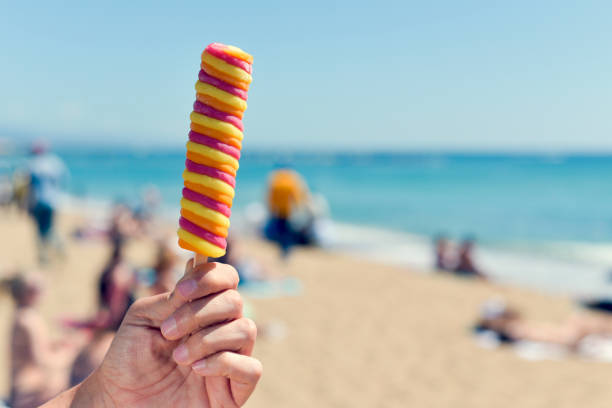 istock man eating a popsicle on the beach 685056578