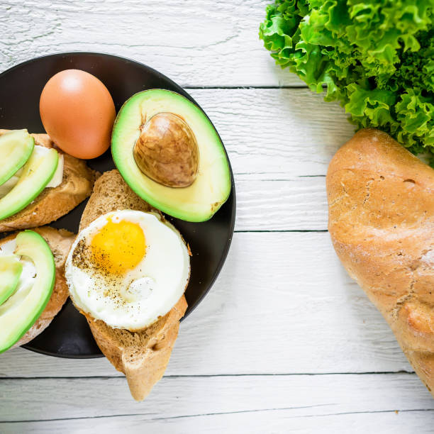 istock Sandwiches with avocado and egg on a dark plate on rustic background. Flat lay. Top view. Tasty breakfast 685057168