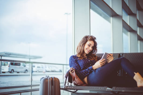 istock Female passenger at airport waiting area using digital tablet 685057414