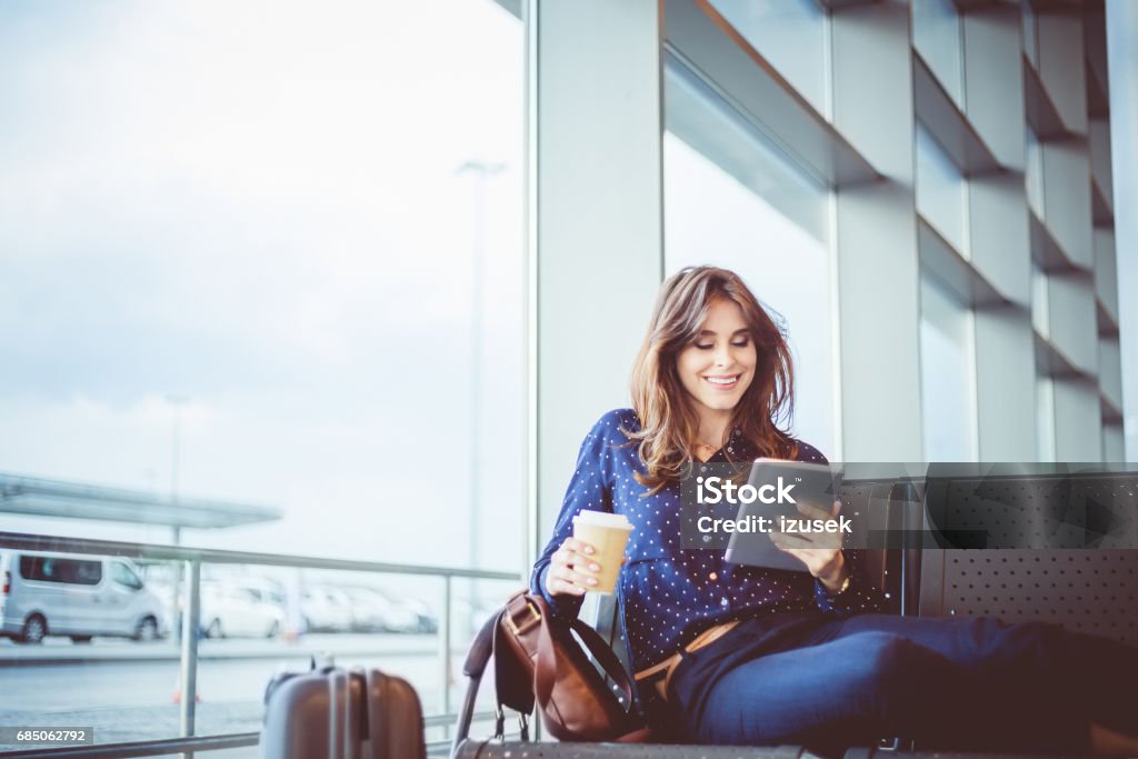 Passagère attend son vol au salon d’aéroport - Photo de Aéroport libre de droits