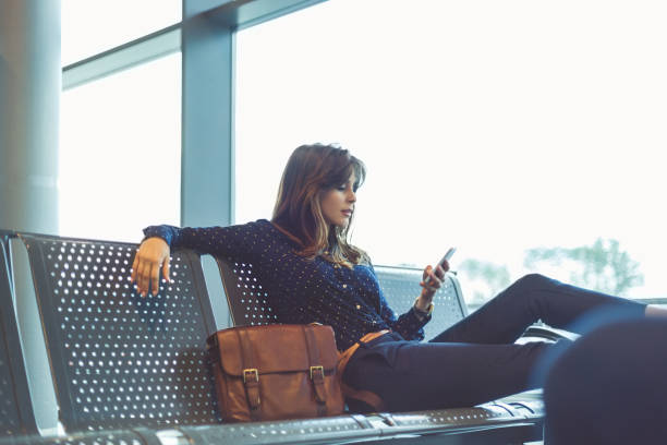 joven espera su vuelo en el salón del aeropuerto - airport waiting room waiting airport lounge fotografías e imágenes de stock