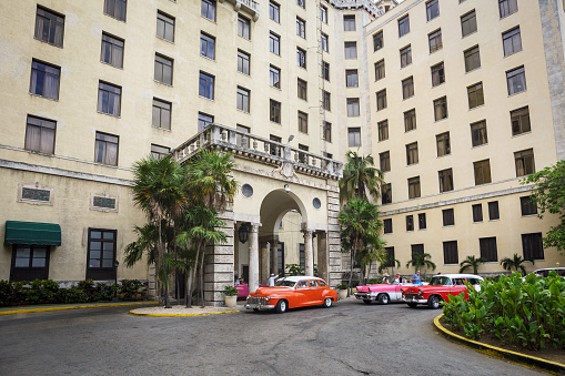Havana, Cuba - March 18, 2017: Colorful and old American made cars parked near the the entrance of the Hotel Nacional de Cuba