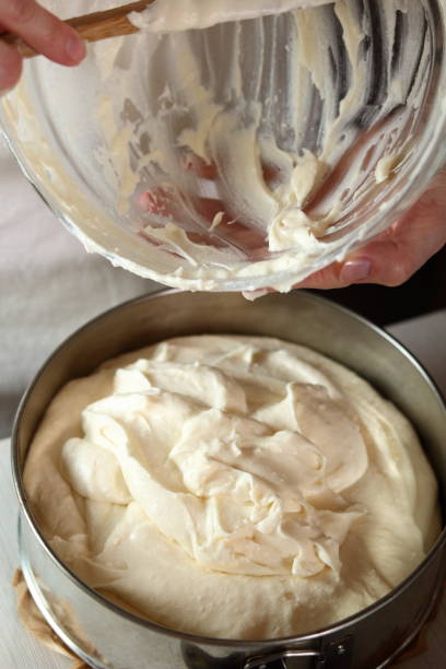 istock Transfer cheese filling into baking pan. Making frozen strawberry cheesecake series. 685071598