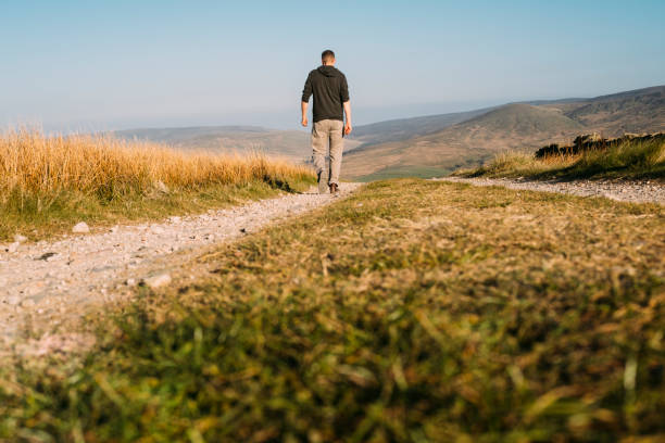 istock man walking along a dirt track in remote location 685087234