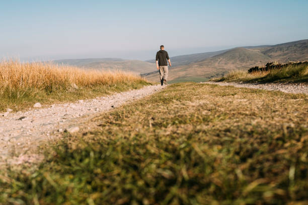 istock man walking along a dirt track in remote location 685087358