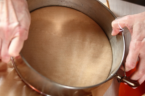 Preparing baking pan. Making frozen strawberry cheesecake series.