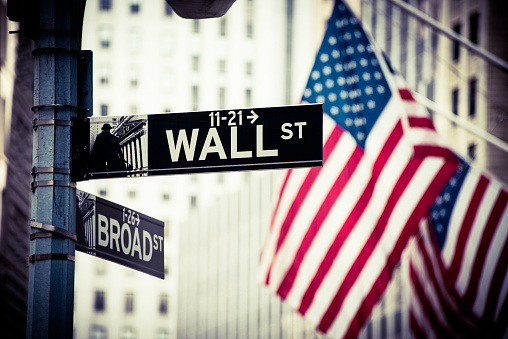 Wall Street and Broad Street Signs with US flags in the background