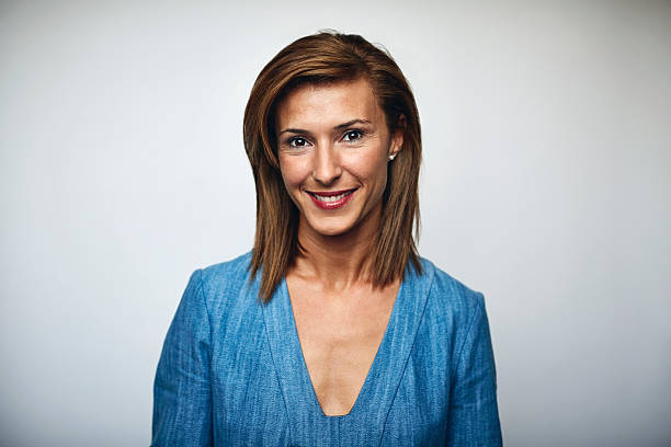 Beautiful businesswoman smiling over white Portrait of beautiful businesswoman smiling. Executive is wearing blue top. Professional is over white background. mid length hair stock pictures, royalty-free photos & images