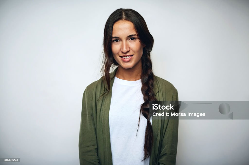 Businesswoman with braided hair over white Portrait of businesswoman with braided hair. Confident female professional is wearing jacket. She is smiling over white background. Portrait Stock Photo