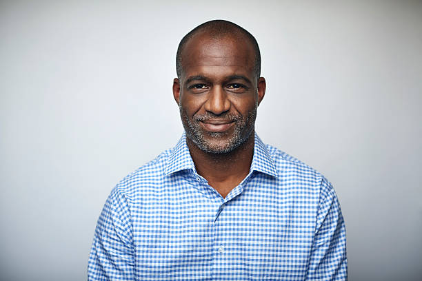 mature businessman smiling over white background - tête et épaules photos et images de collection