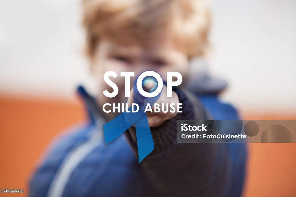 Stop child abuse. Child pressing stop child abuse awareness symbol on projection screen. Blue ribbon as sing of child abuse social issues. Abuse Stock Photo