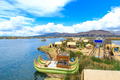 Unidentified women in traditional dresses welcome tourists in Uros Island