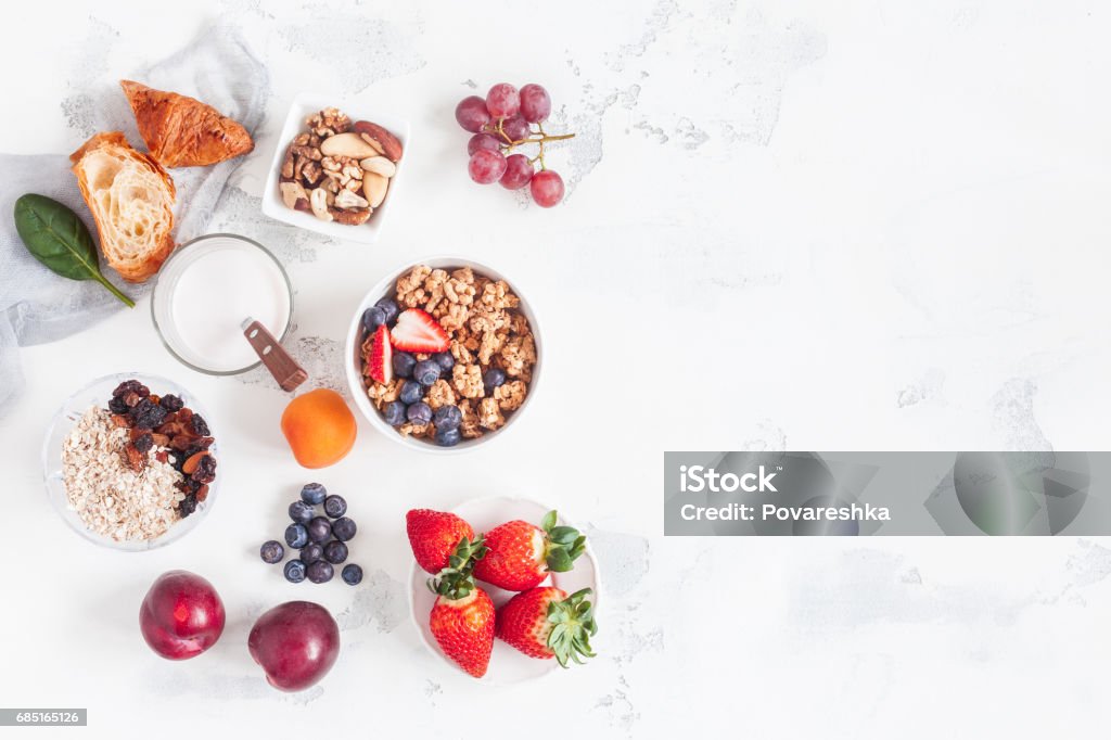 Healthy breakfast with muesli, yogurt, fruits, berries, nuts Healthy breakfast with muesli, yogurt, fruits, berries, nuts on white background. Flat lay, top view Breakfast Stock Photo