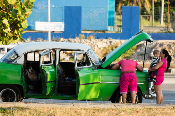 jeune couple cubain et broaken vintage voiture - cuba car chevrolet havana photos et images de collection